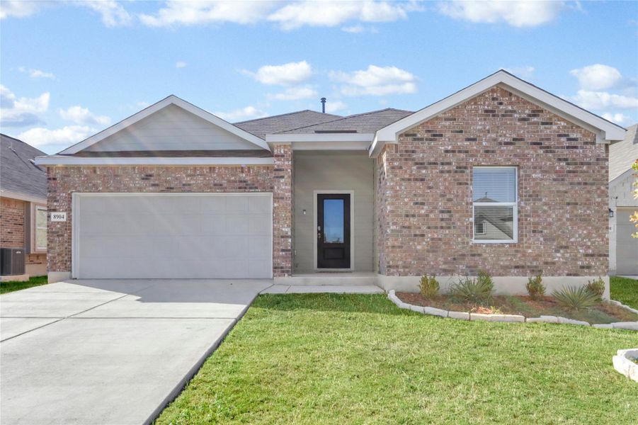 Ranch-style house with brick siding, driveway, a garage, and a front yard