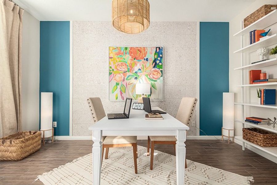 A room with a table and a lamp and a painting on the wall. A room with a table and a lamp and a painting on the wall.