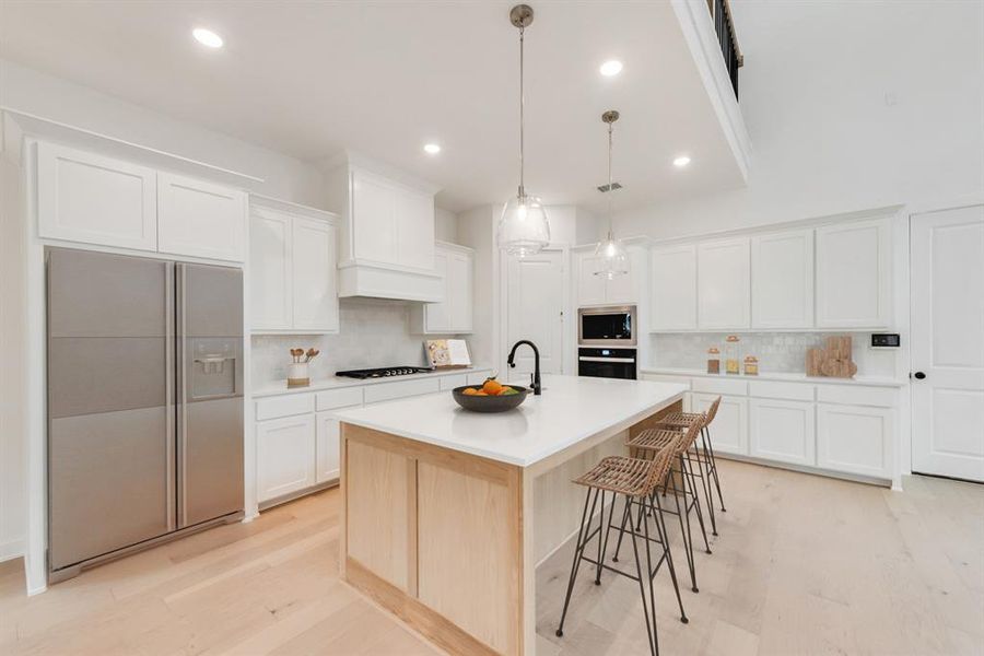 Kitchen with stainless steel appliances, light wood-style floors, tasteful backsplash, white cabinets, and recessed lighting Kitchen with stainless steel appliances, light wood-style floors, tasteful backsplash, white cabinets, and recessed lighting