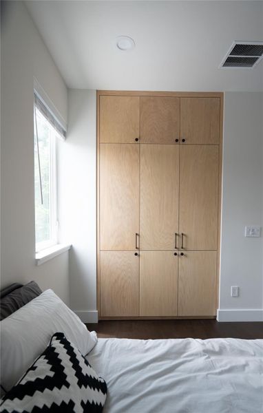 Bedroom built-ins; hanging storage, shelves below, storage for seasonal items above.