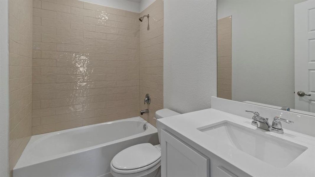 Full bathroom with shower combination, vanity, and a textured wall Full bathroom with shower combination, vanity, and a textured wall