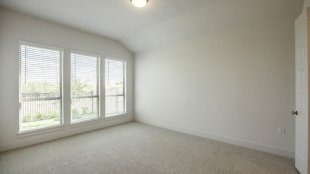 Empty room with vaulted ceiling and carpet Empty room with vaulted ceiling and carpet