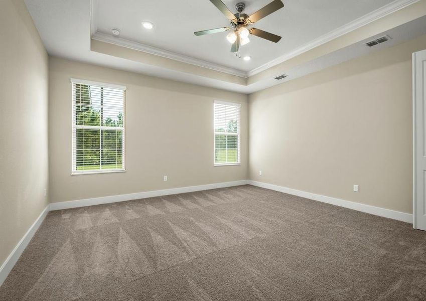 Master bedroom with carpet, windows and a ceiling fan.