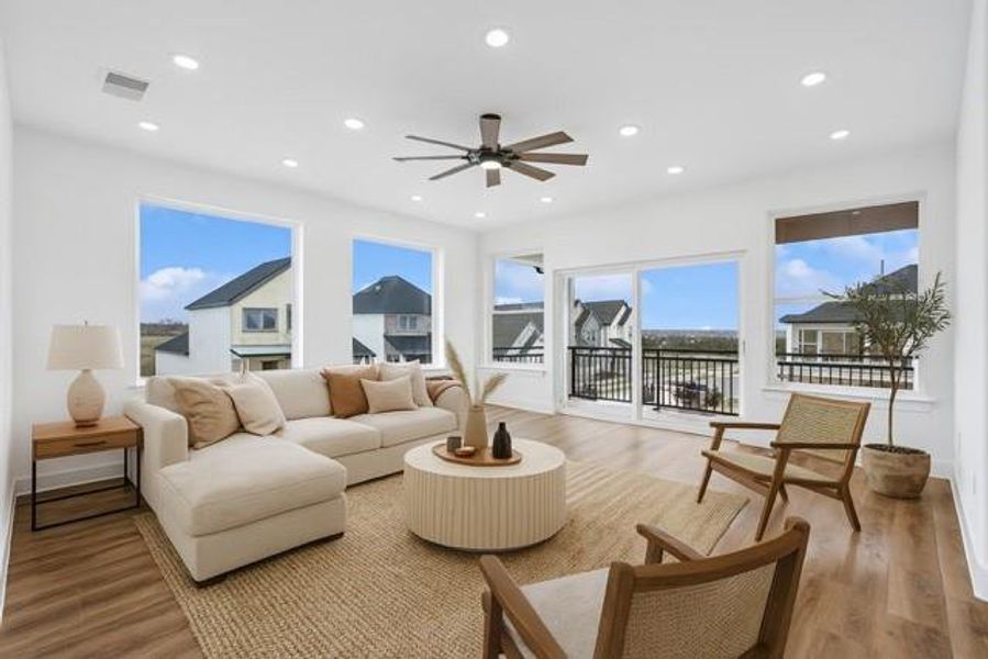 Living area with a ceiling fan, light wood-style floors, and recessed lighting, virtually staged
