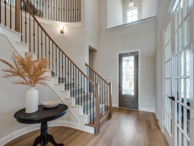 Entryway featuring french doors, hardwood / wood-style flooring, a high ceiling, and a wealth of natural light