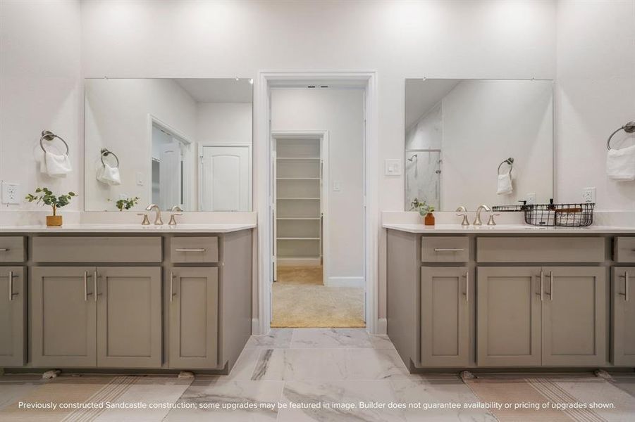 Dual vanities flank either side of the bathroom entry door, with two closets - one easily accessible from the bathroom and another just outside for additional storage.