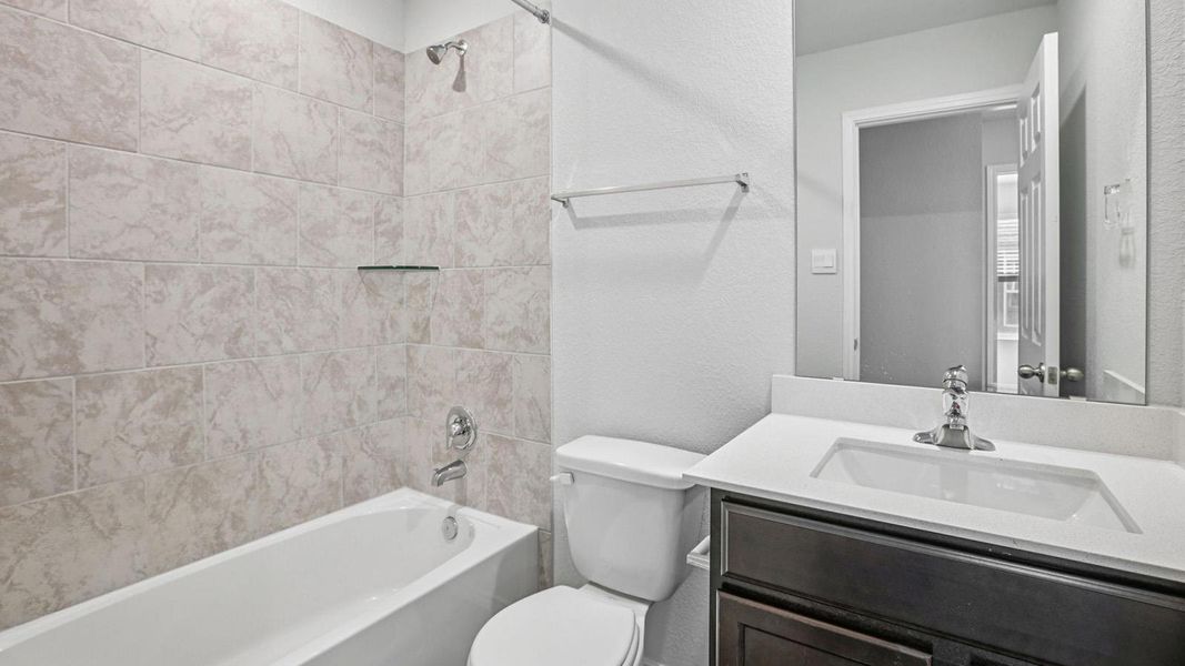 A well-appointed bathroom offers a clean vanity with a large mirror and a tiled shower/tub combination. A well-appointed bathroom offers a clean vanity with a large mirror and a tiled shower/tub combination.