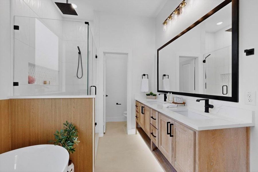 Full bathroom with double vanity, a shower stall, and a soaking tub