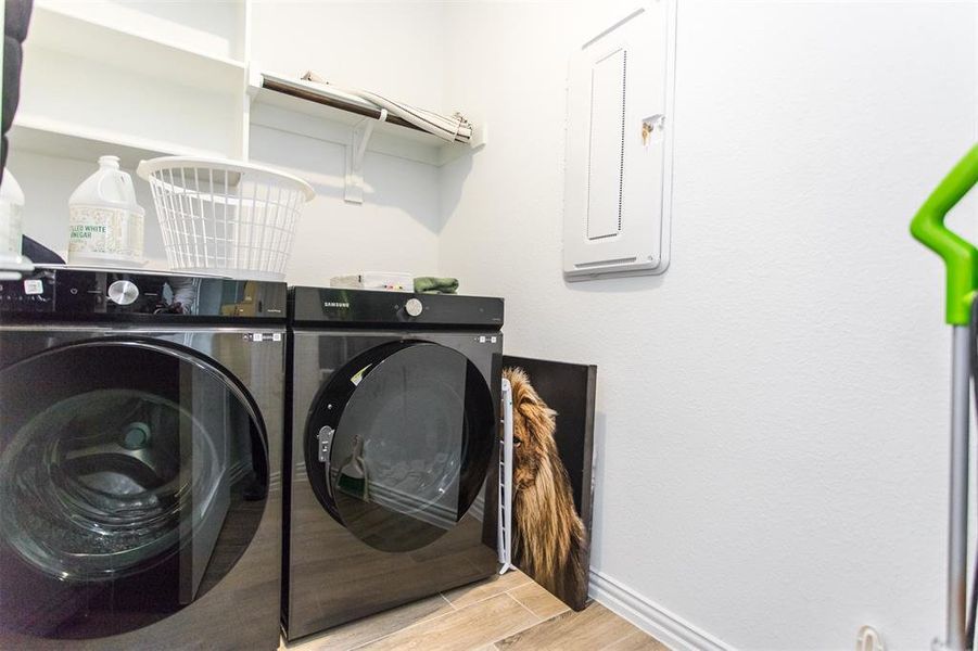 Laundry room with washer and clothes dryer and electric panel