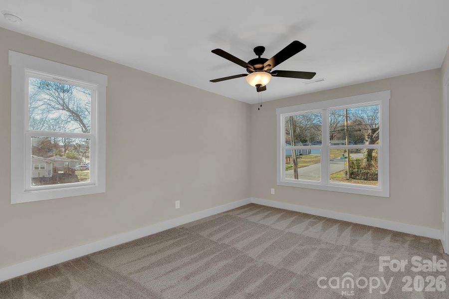 Primary bedroom with multiple windows and soft natural light