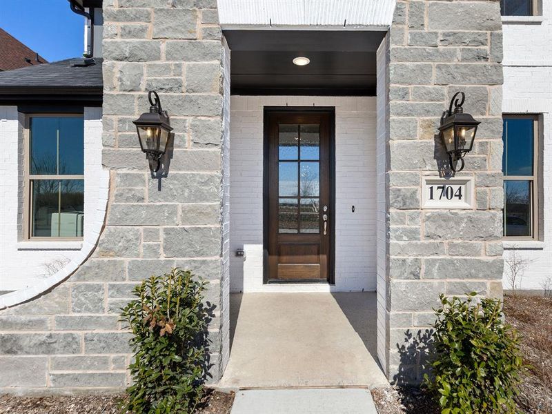 Beautiful white brick flanked with grey stone create a stunning entry to your new dream home!