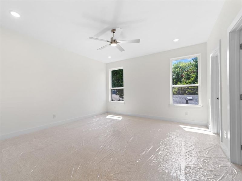 Unfurnished bedroom with carpet, multiple windows, recessed lighting, and a ceiling fan