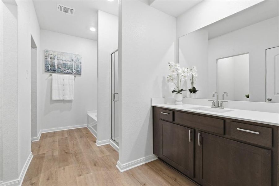 Bathroom featuring a dark wood vanity with a white countertop and a large mirror