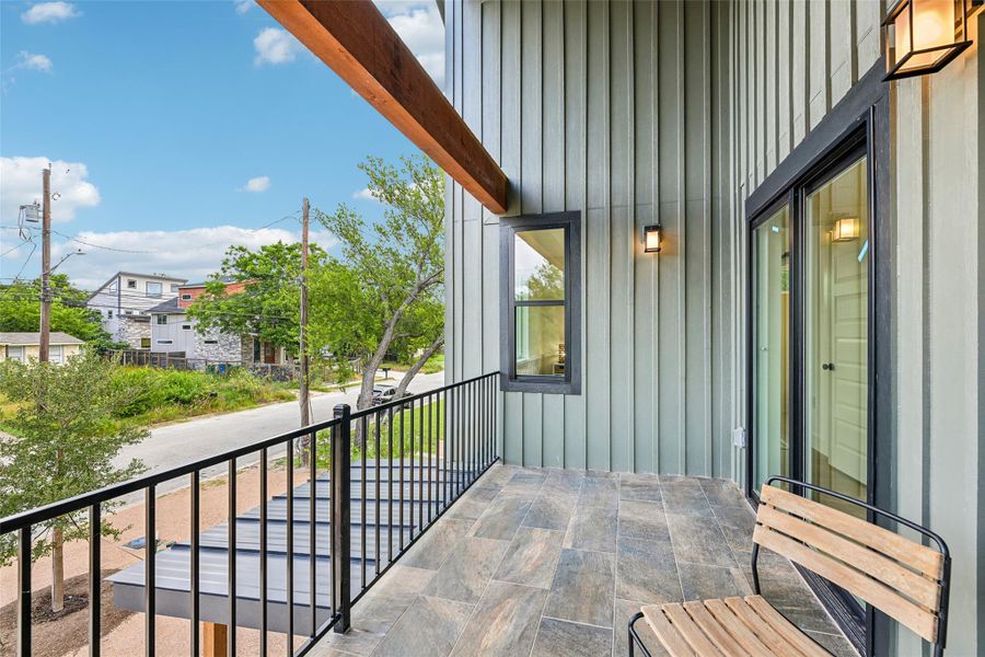 An inviting private balcony provides an elevated view of the surrounding neighborhood.
