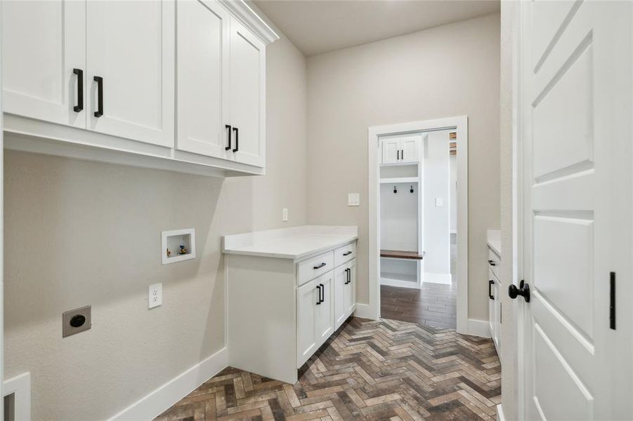 From the Primary closet directly into the laundry area.  Custom flooring, and cabinetry offers plenty of space for storage!