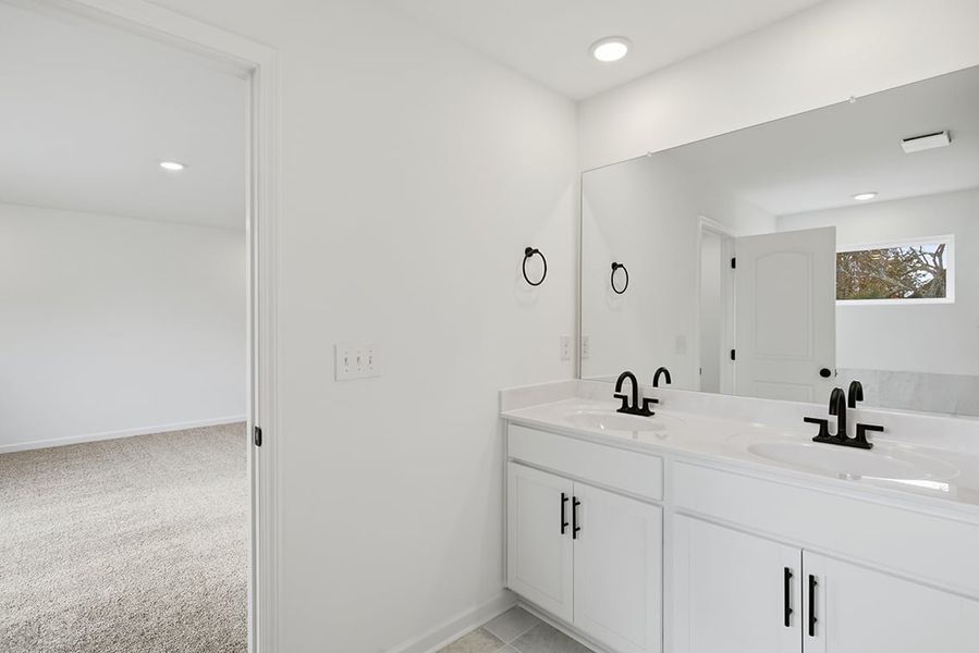 A bathroom with white cabinets.