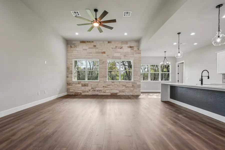 Unfurnished living room with dark wood-type flooring, a ceiling fan, and recessed lighting