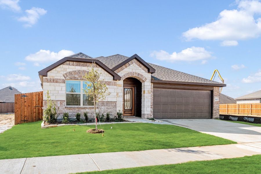 Single-story brick and stone home with arched entry, two-car garage, and green front lawn