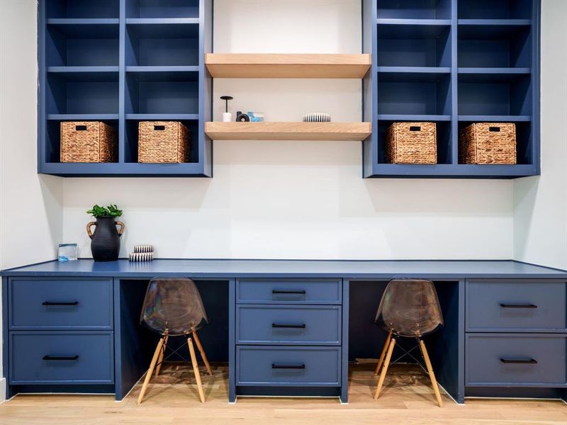 Office with built in study area and light wood finished floors