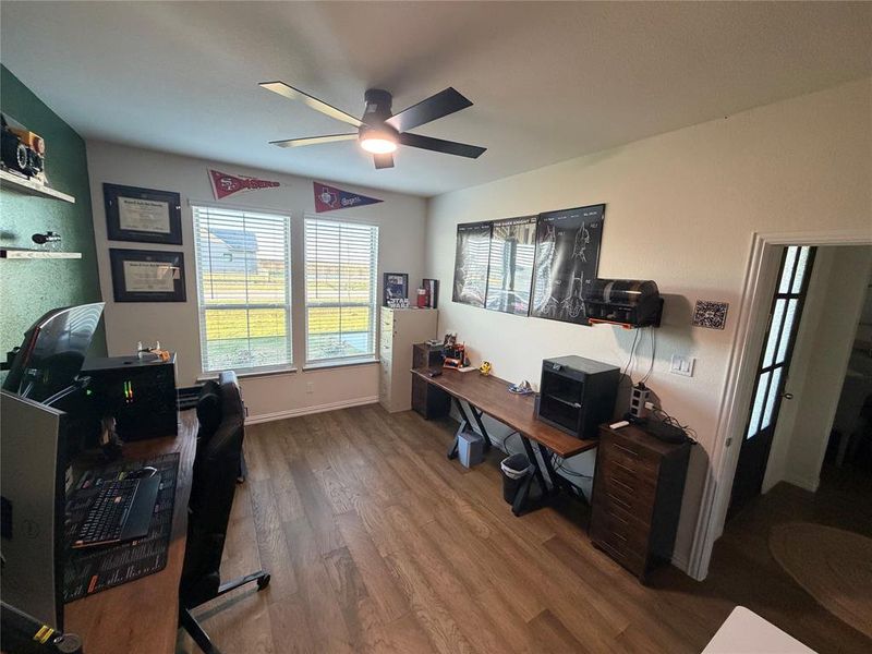Office area with dark wood finished floors and ceiling fan