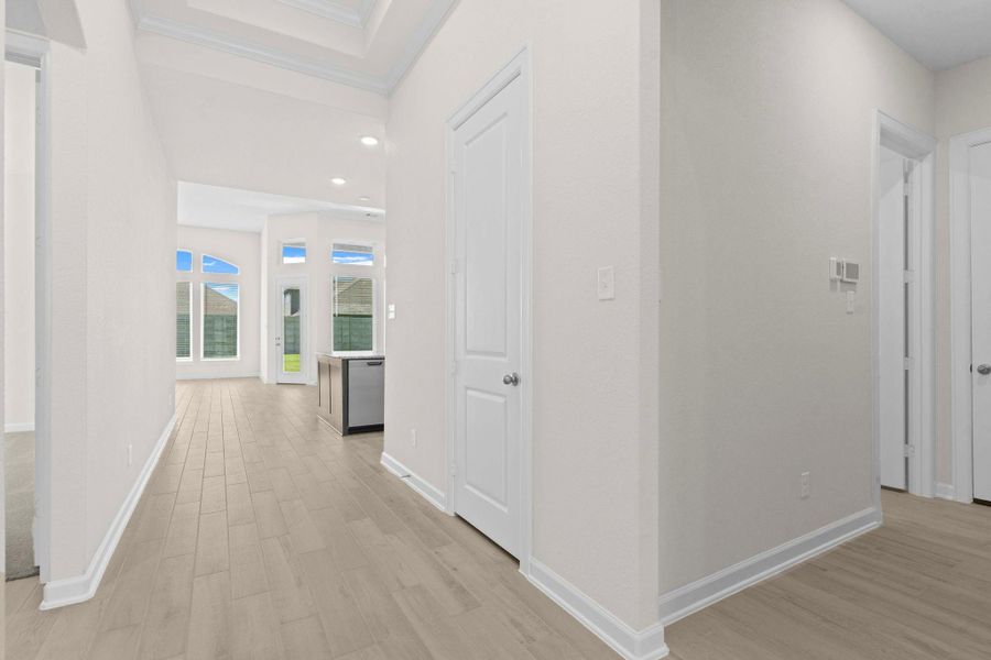 Hallway view leading into the open living areas, with tall ceilings and abundant natural light creating a welcoming flow.