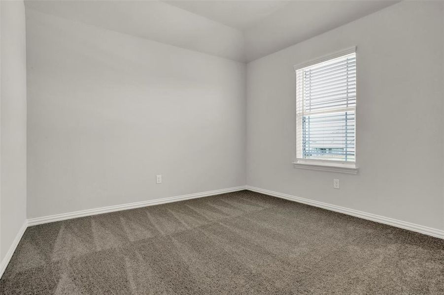 Empty room featuring dark colored carpet