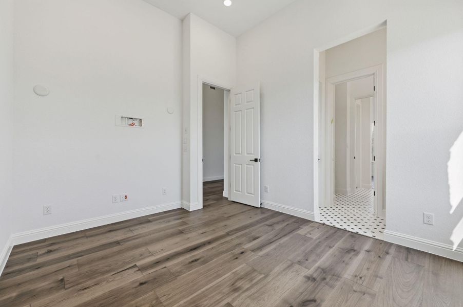 Unfurnished bedroom with wood finished floors and baseboards
