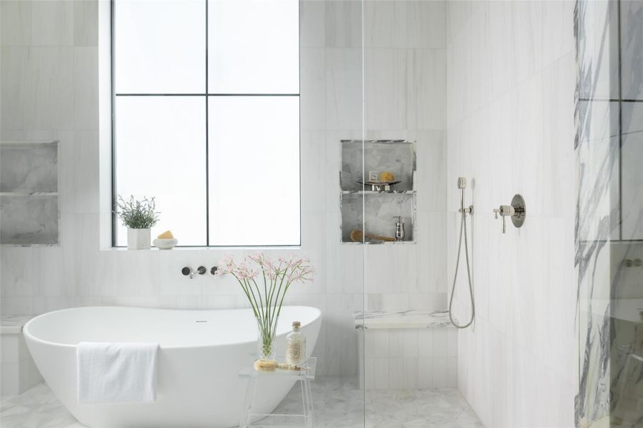 A luxurious soaking tub sits within the wet room, surrounded by floor-to-ceiling designer tile. A luxurious soaking tub sits within the wet room, surrounded by floor-to-ceiling designer tile.