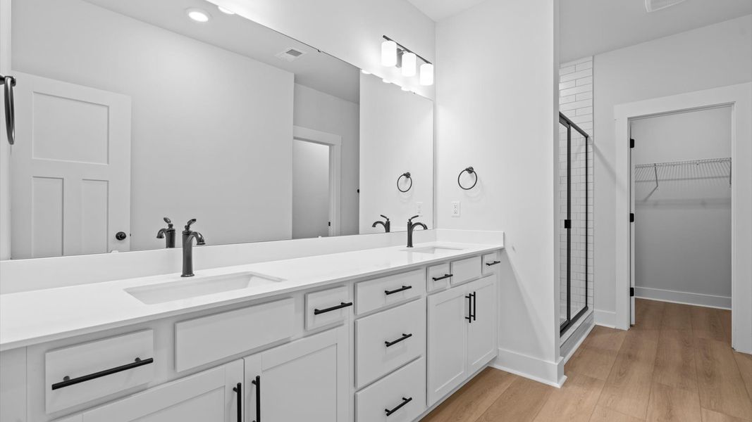 Exceptional en-suite with dual vanity and glass-enclosed tiled walk-in shower for superior everyday comfort