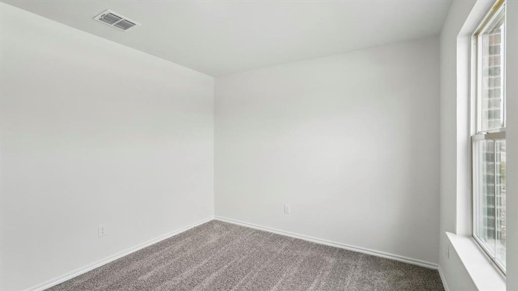 Room with light gray carpeting, white walls, and a single-pane window