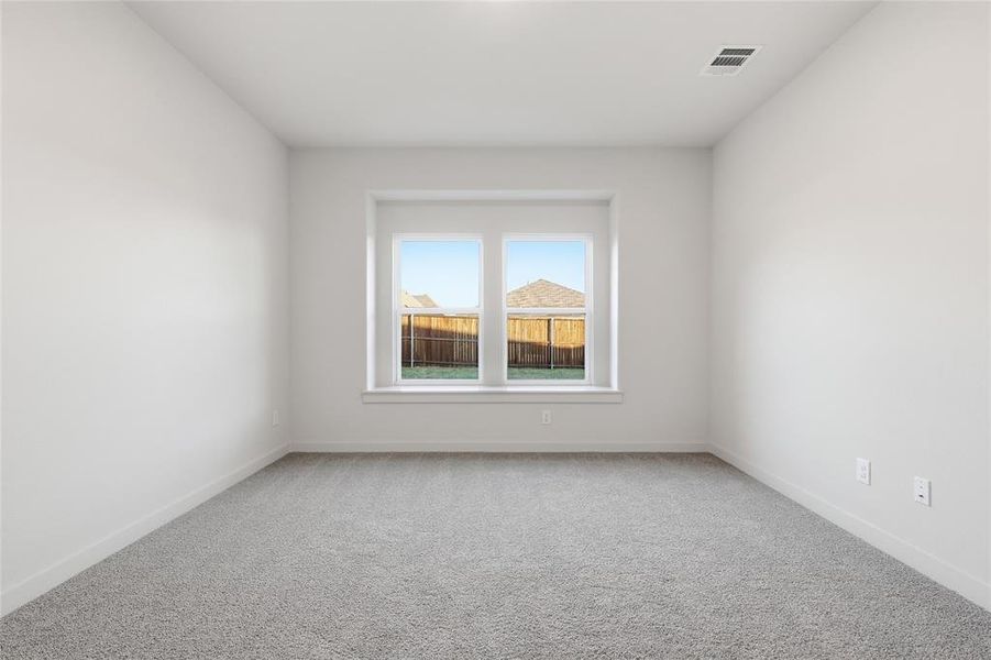 Spacious interior room with light gray carpeting and white painted walls Spacious interior room with light gray carpeting and white painted walls