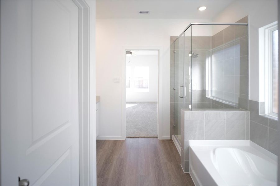 Master bathroom with separate tub and walk in shower.