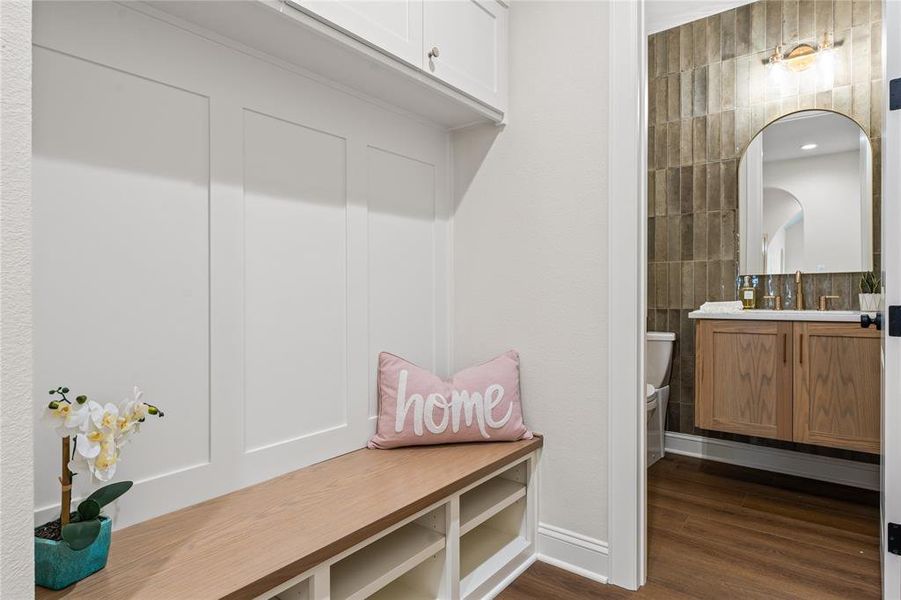Mudroom featuring dark wood-style flooring and tile walls