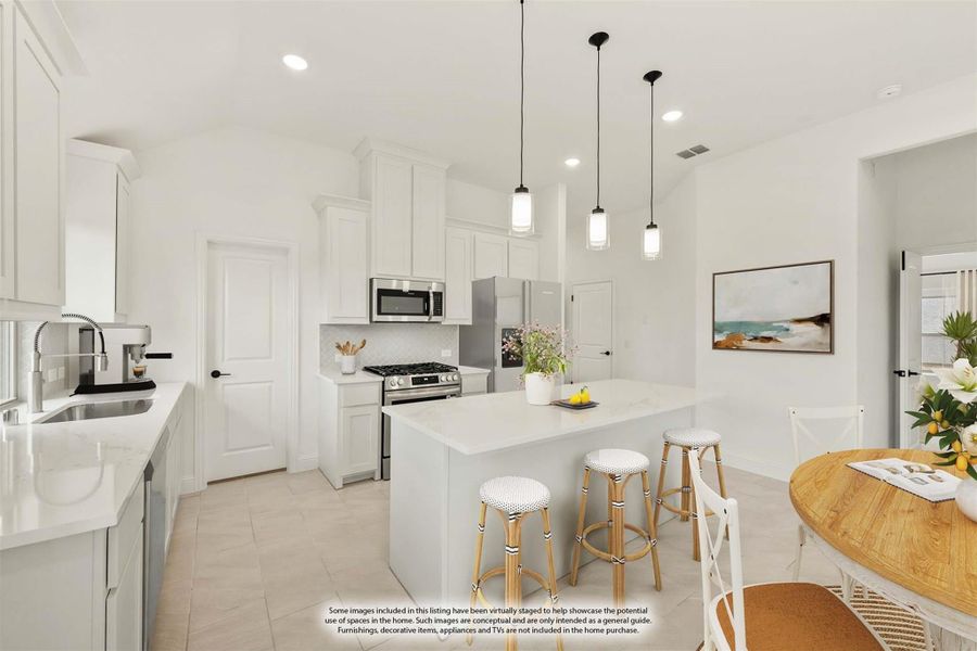 White kitchen with center island, bar stools, stainless steel appliances, and pendant lights above the island.