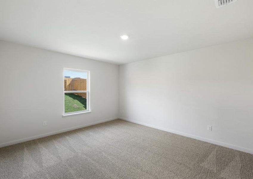 The spacious master bedroom has a large window that lets in natural light and backyard views.