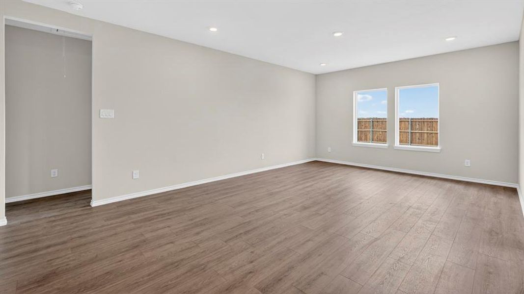 Open-concept living space featuring wood-finish flooring, recessed lighting, and neutral wall tones