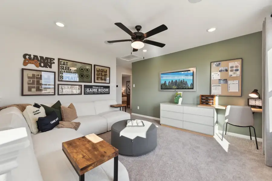 A living room with a couch and a fan. A living room with a couch and a fan.