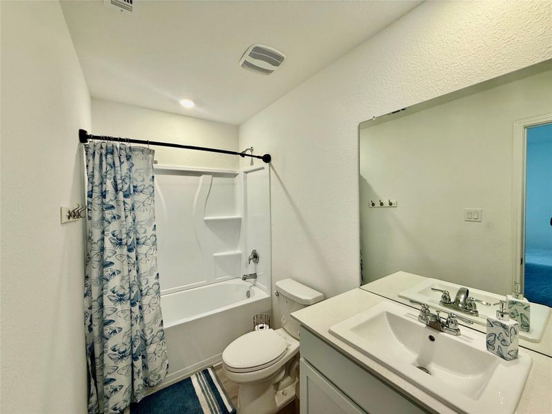 Bathroom featuring vanity and shower / bath combo with shower curtain