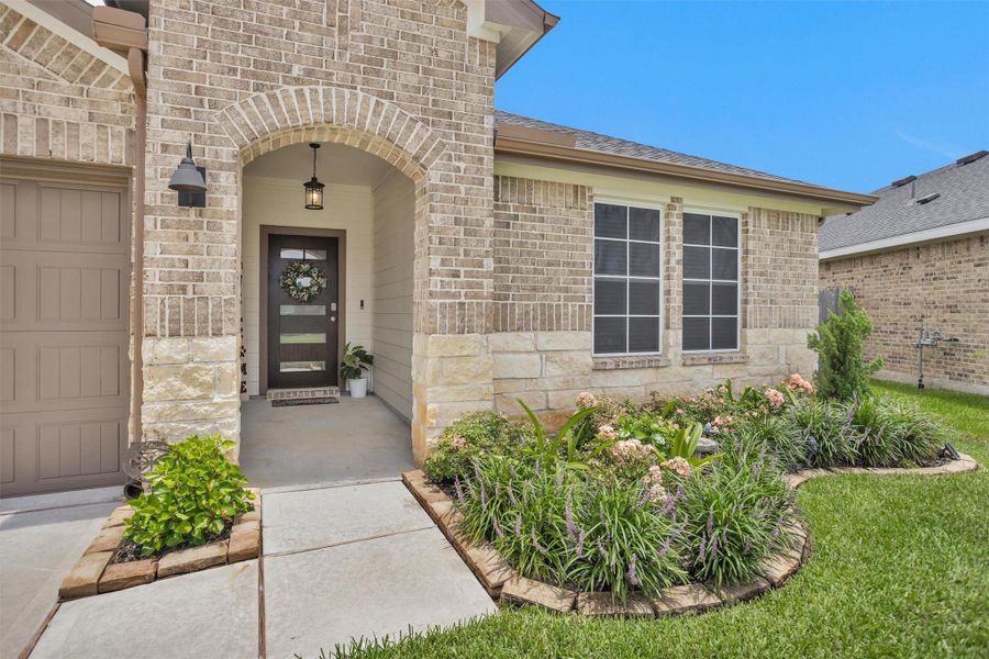 Brick and Stone Home., with a welcoming arched entryway. All sides of the home are brick.