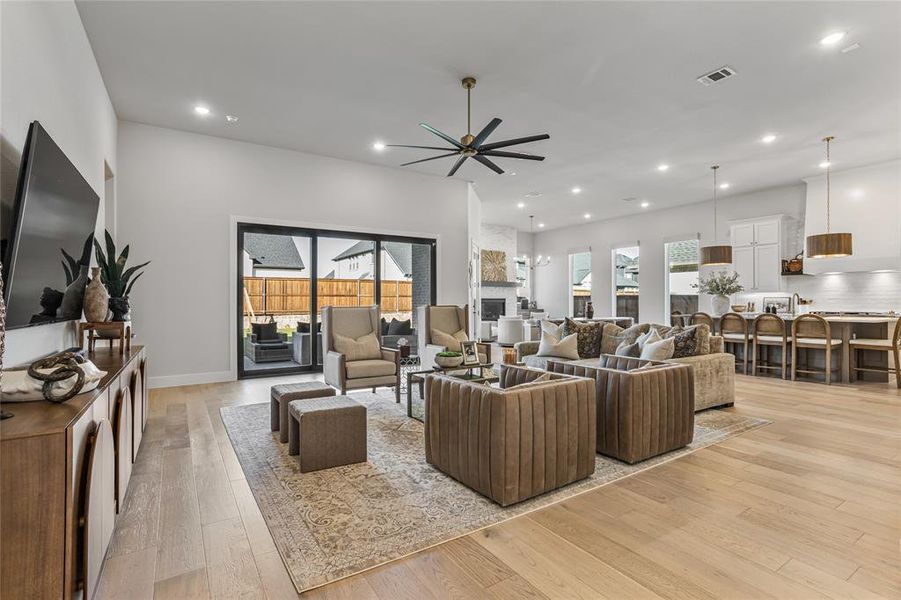 Spacious living room with a custom three panel sliding glass door, wood flooring and custom oversized fan