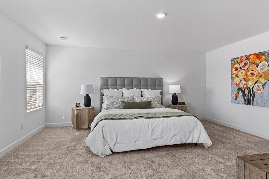 A bedroom with a bed and lamps.