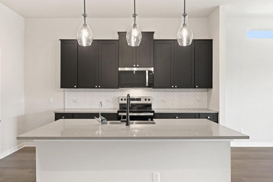 Kitchen with decorative backsplash, dark wood-style flooring, and light stone countertops