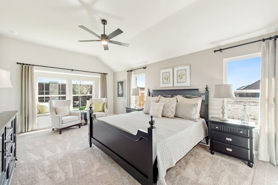 Master bedroom with vaulted ceiling, dark wood four-poster bed, ceiling fan, and sitting area near large windows Master bedroom with vaulted ceiling, dark wood four-poster bed, ceiling fan, and sitting area near large windows