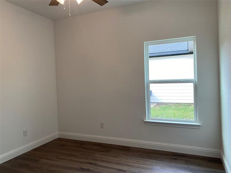 Bedroom with dark wood-style floors and a ceiling fan Bedroom with dark wood-style floors and a ceiling fan