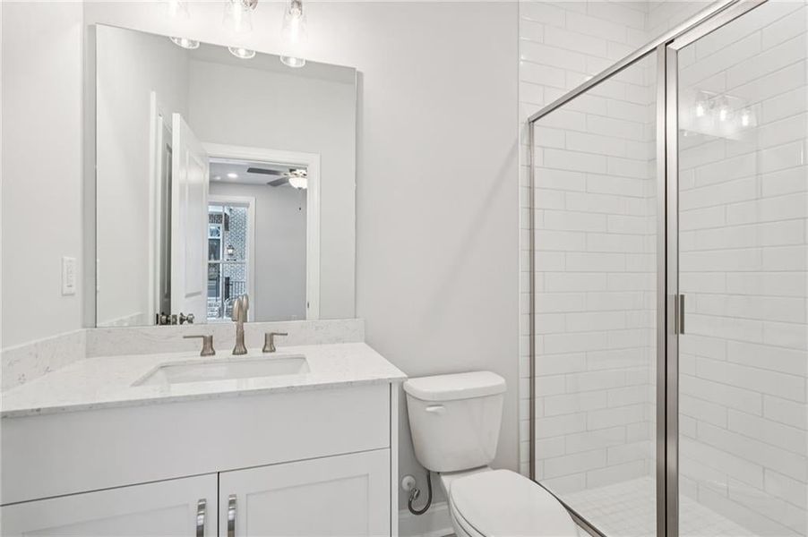 Bathroom with vanity, a stall shower, and ceiling fan