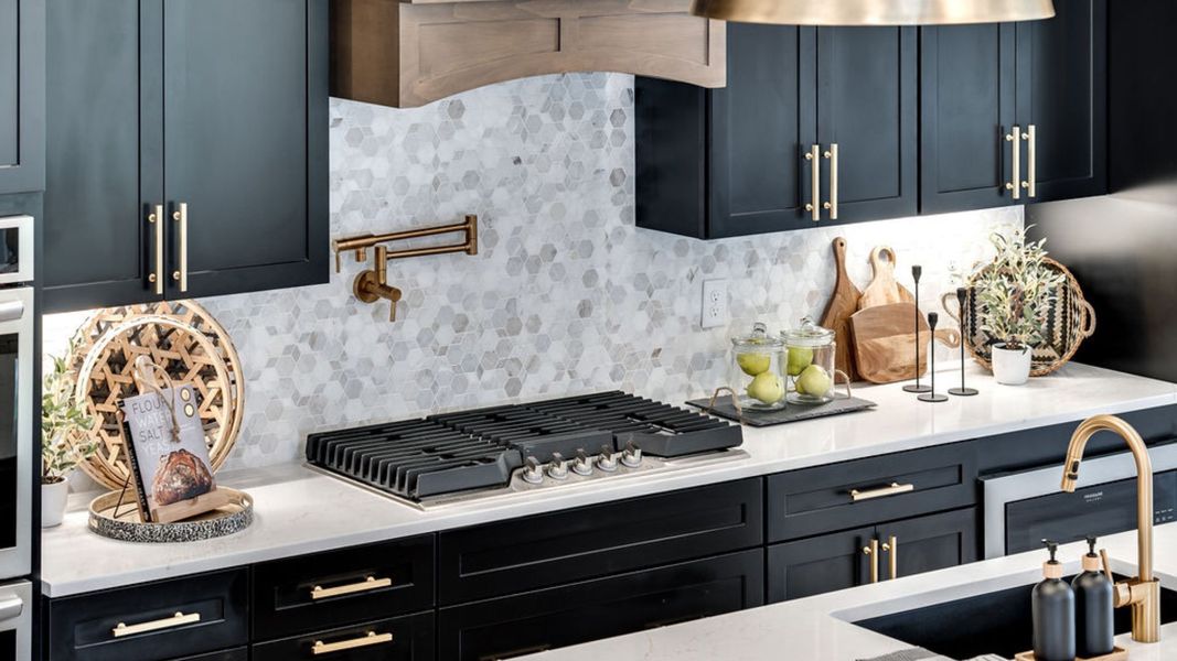 Kitchen with dark cabinetry, quartz countertops, and tile backsplash Kitchen with dark cabinetry, quartz countertops, and tile backsplash