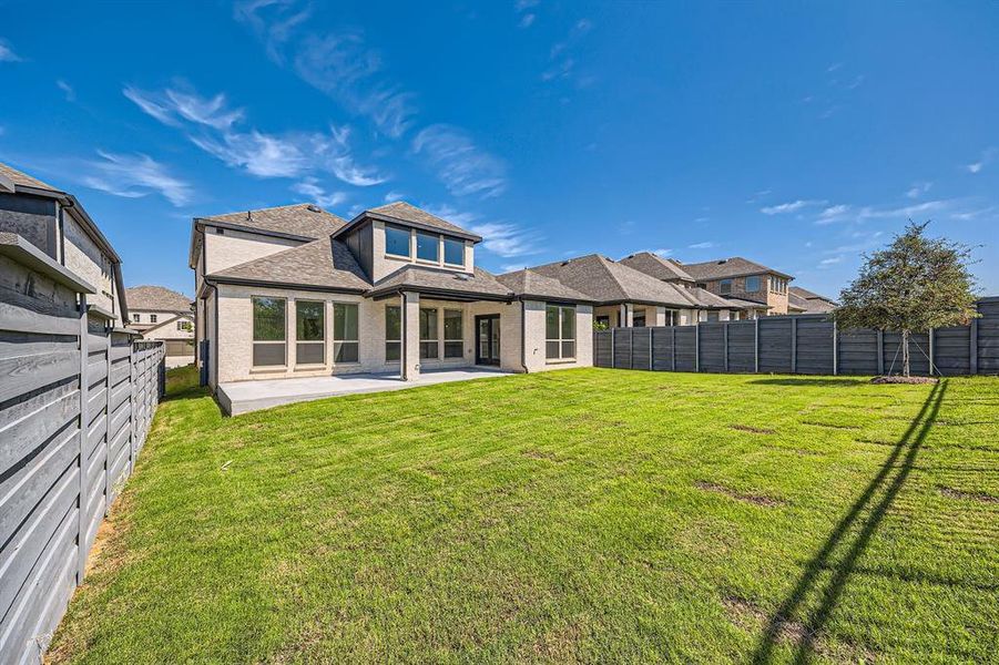 Back of house with a patio and a yard