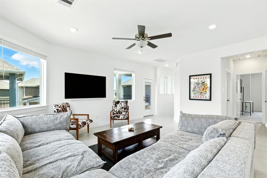 Living room features tile flooring, aceiling fan, high ceilings, and large windows. Living room features tile flooring, aceiling fan, high ceilings, and large windows.
