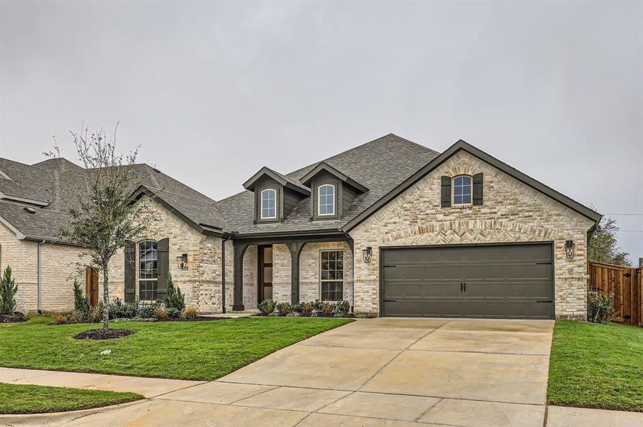 French country style house with a garage and a front lawn