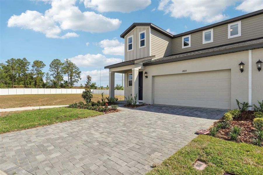 Front exterior of a new home in Cyrene at Minneola - Villas, Minneola, FL, highlighting curb appeal (Image 19).